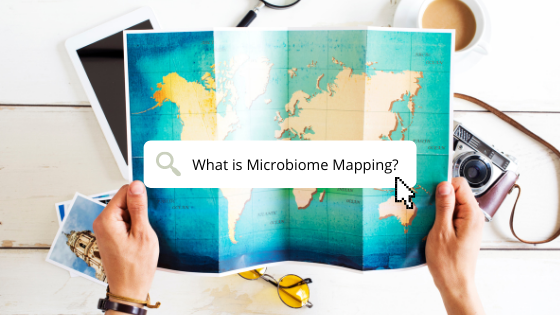 Man holding a map of the world with the text "what is microbiome mapping?"