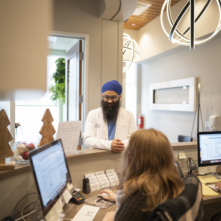 Dr. Singh Harsimranjeet talking to a receptionist