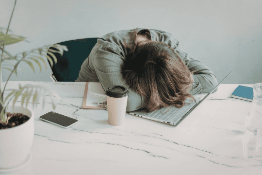 Woman putting her head down on desk